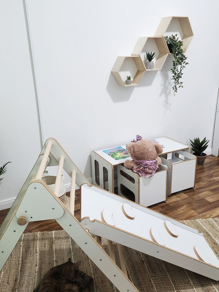 The Pikler Triangle with Slide and Climbing Ramp is an expanded version of the well-known Pickler Triangle toy, which includes a slide and climbing ramp. This toy is designed to help children develop their motor skills, balance, and self-confidence through exploration and active play.